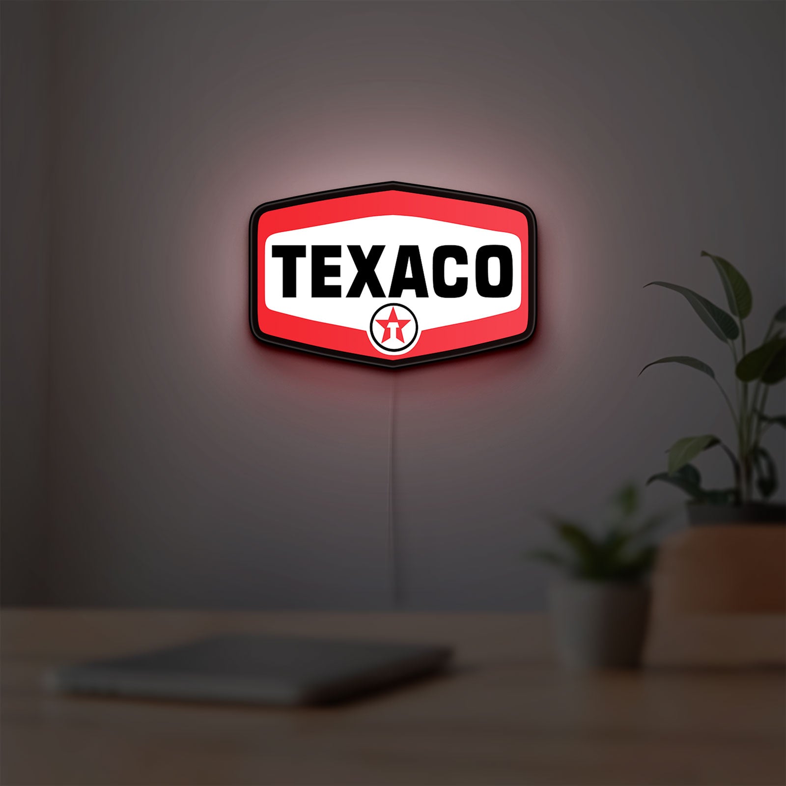 Texaco LED lightbox hanging on a room wall with soft red light