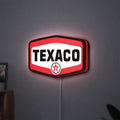 Texaco LED lightbox hanging on a wall with red glow