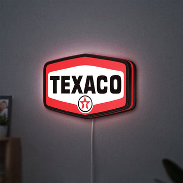 Texaco LED lightbox hanging on a wall with red glow
