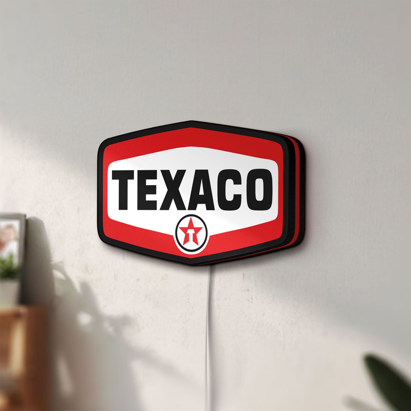 Unlit Texaco LED lightbox mounted on a wall in daylight