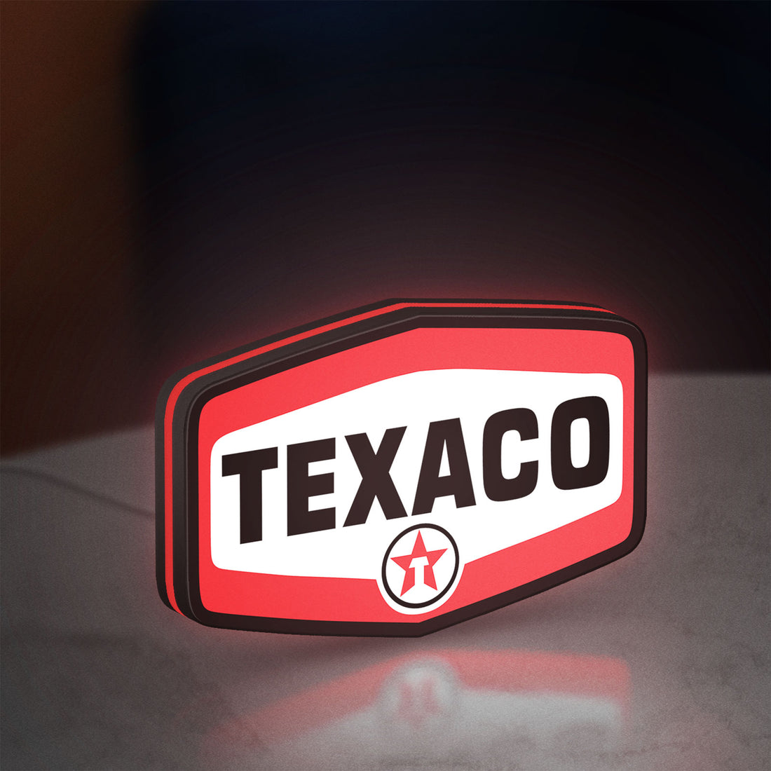Texaco LED lightbox hanging on a wall with red glow