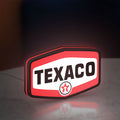 Texaco LED lightbox standing on a desk from an angled side view with red glow