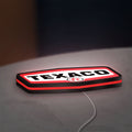 Texaco LED lightbox lying flat on a desk with red glow