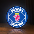 Front view of SAAB Scania LED lightbox sign glowing on a wooden desk