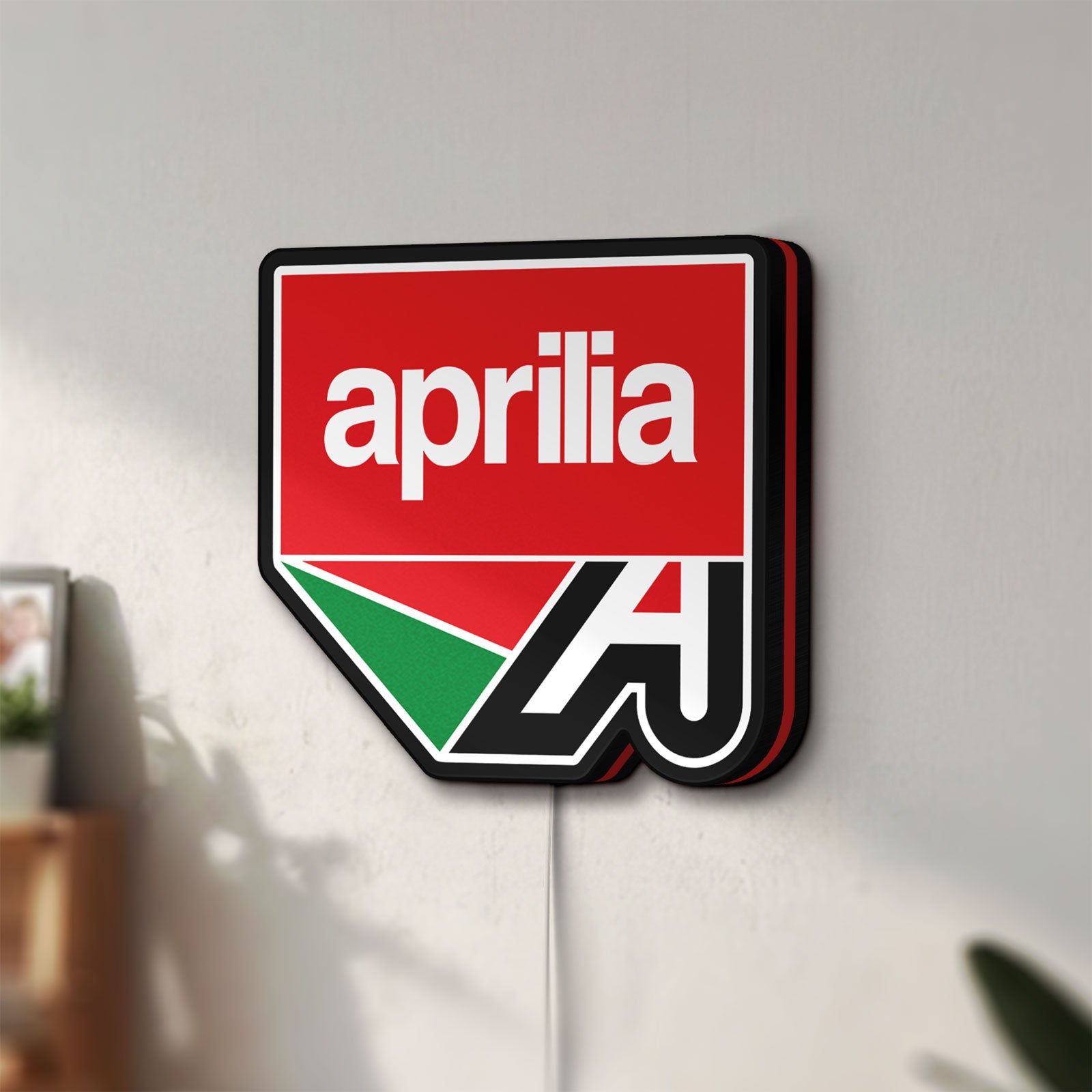 Unlit Aprilia LED lightbox mounted on a wall in daylight