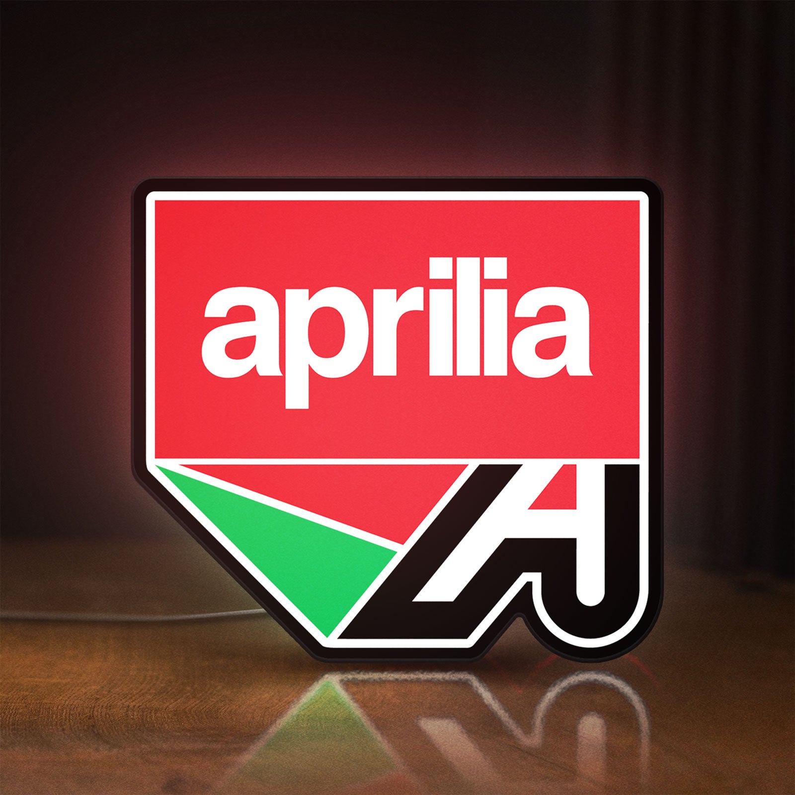 Front view of Aprilia LED lightbox sign glowing on a wooden desk
