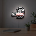 32UNU SHOP LED lightbox hanging on a room wall with soft white light