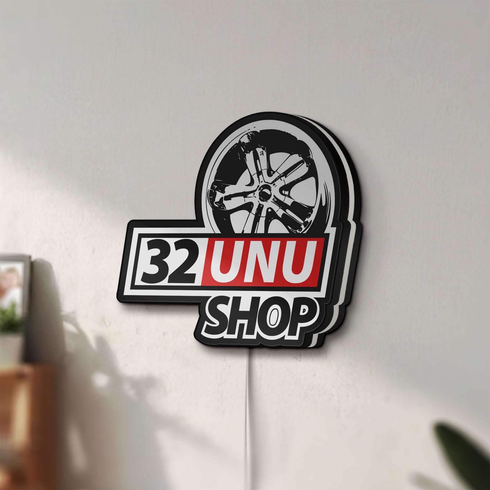 Unlit 32UNU SHOP LED lightbox mounted on a wall in daylight