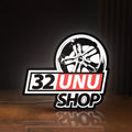 Front view of 32UNU SHOP LED lightbox sign glowing on a wooden desk