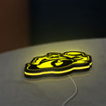 Ting'Avert Moto LED lightbox lying flat on a desk with yellow glow