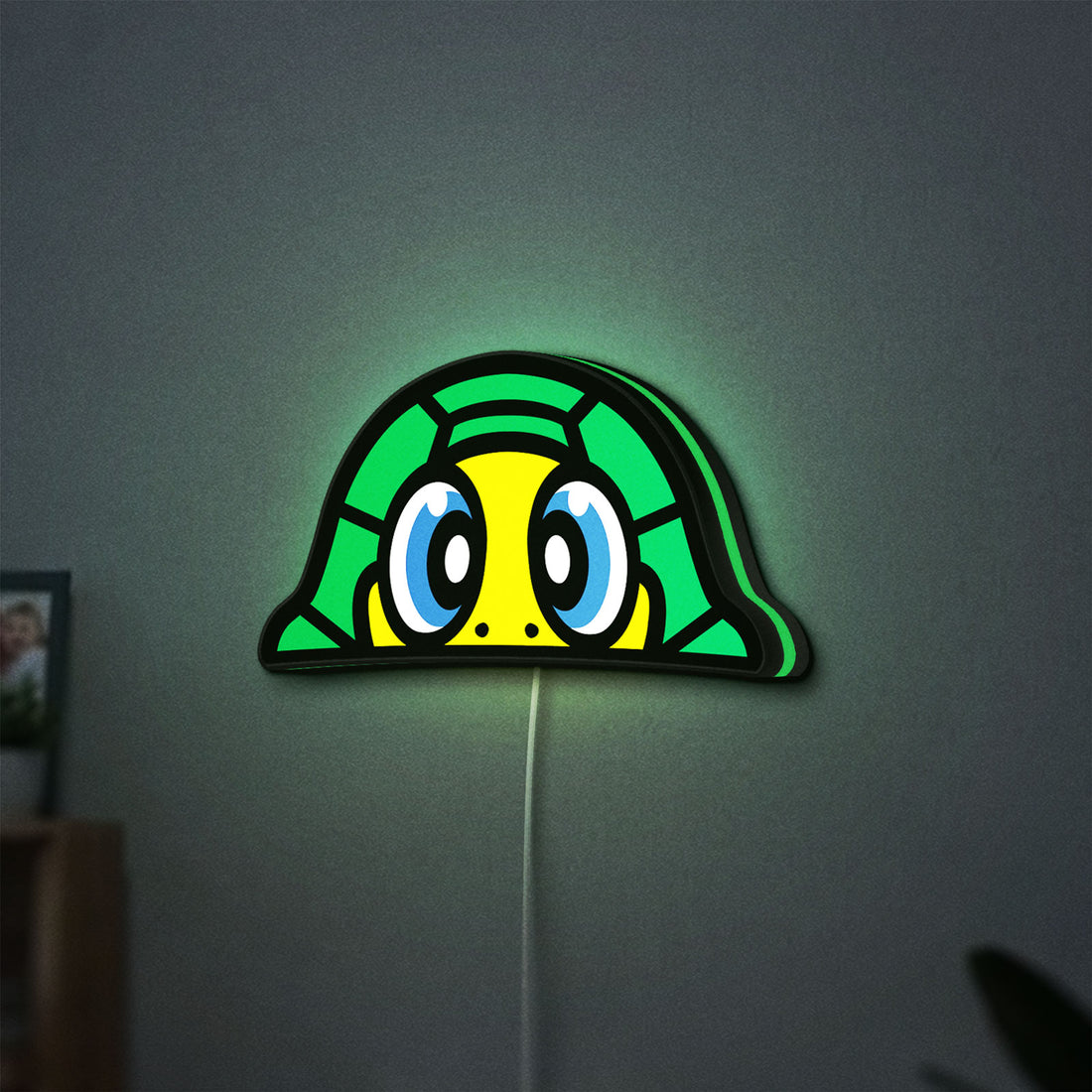 TURTLE ROSSI LED lightbox hanging on a wall with green glow