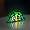 TURTLE ROSSI LED lightbox standing on a desk from an angled side view with green glow