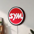 Unlit SYM Sanyang Scooters Motorcycle LED lightbox mounted on a wall in daylight