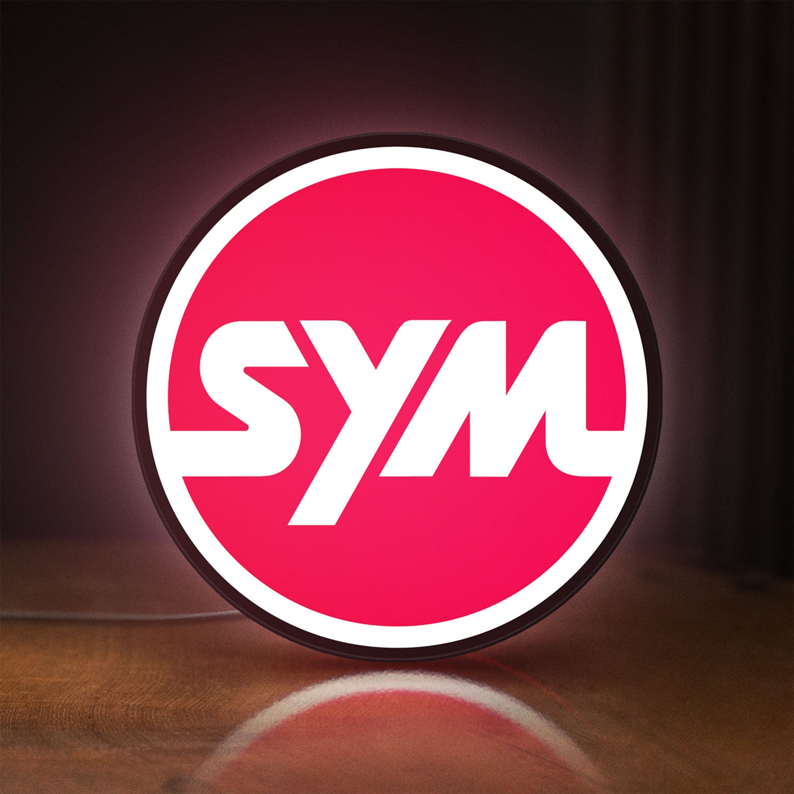 Front view of SYM Sanyang Scooters Motorcycle LED lightbox sign glowing on a wooden desk