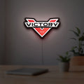 Victory Motorcycles LED lightbox hanging on a room wall with soft red light