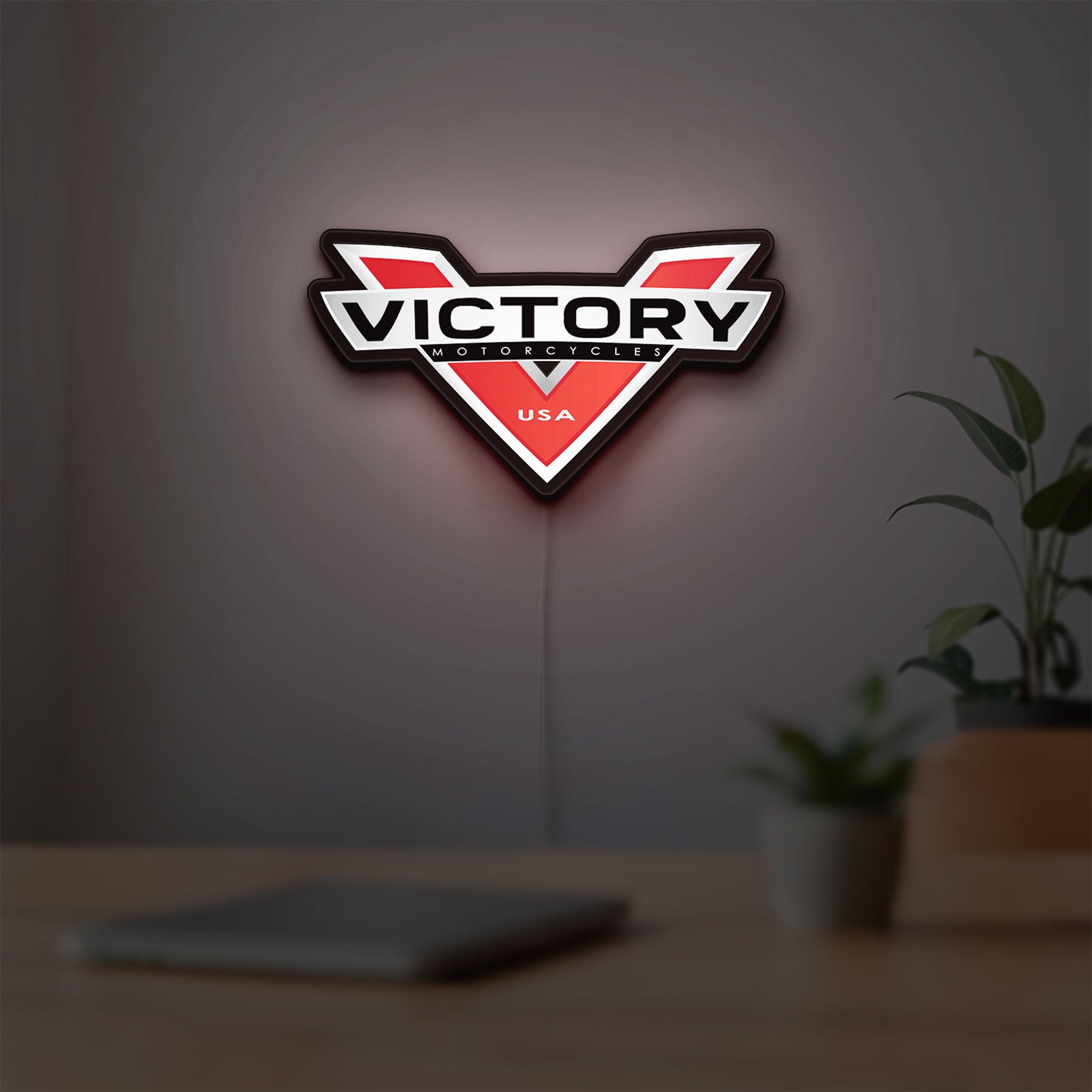 Victory Motorcycles LED lightbox hanging on a room wall with soft red light