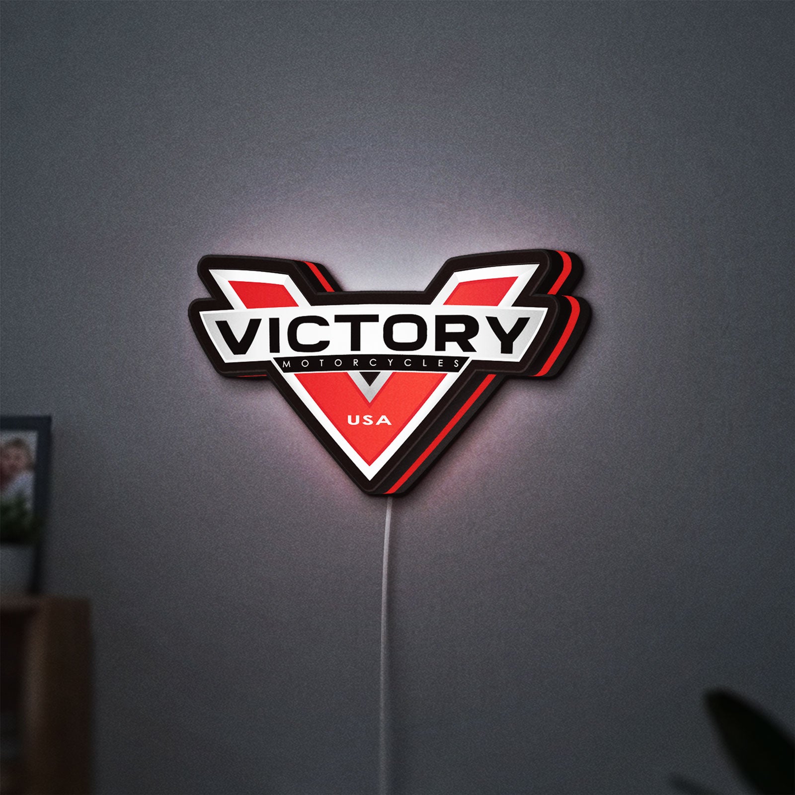 Victory Motorcycles LED lightbox hanging on a wall with red glow