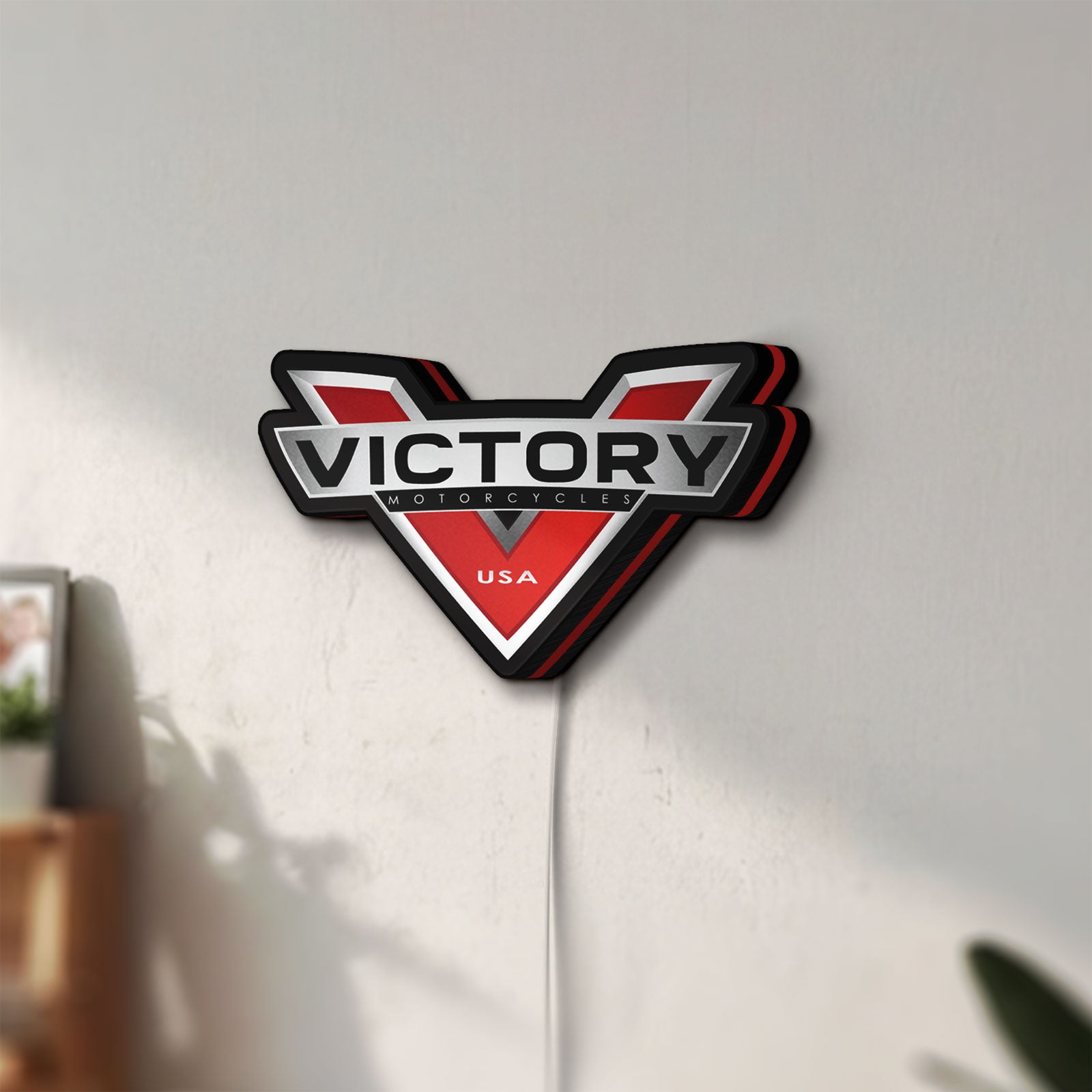 Unlit Victory Motorcycles LED lightbox mounted on a wall in daylight