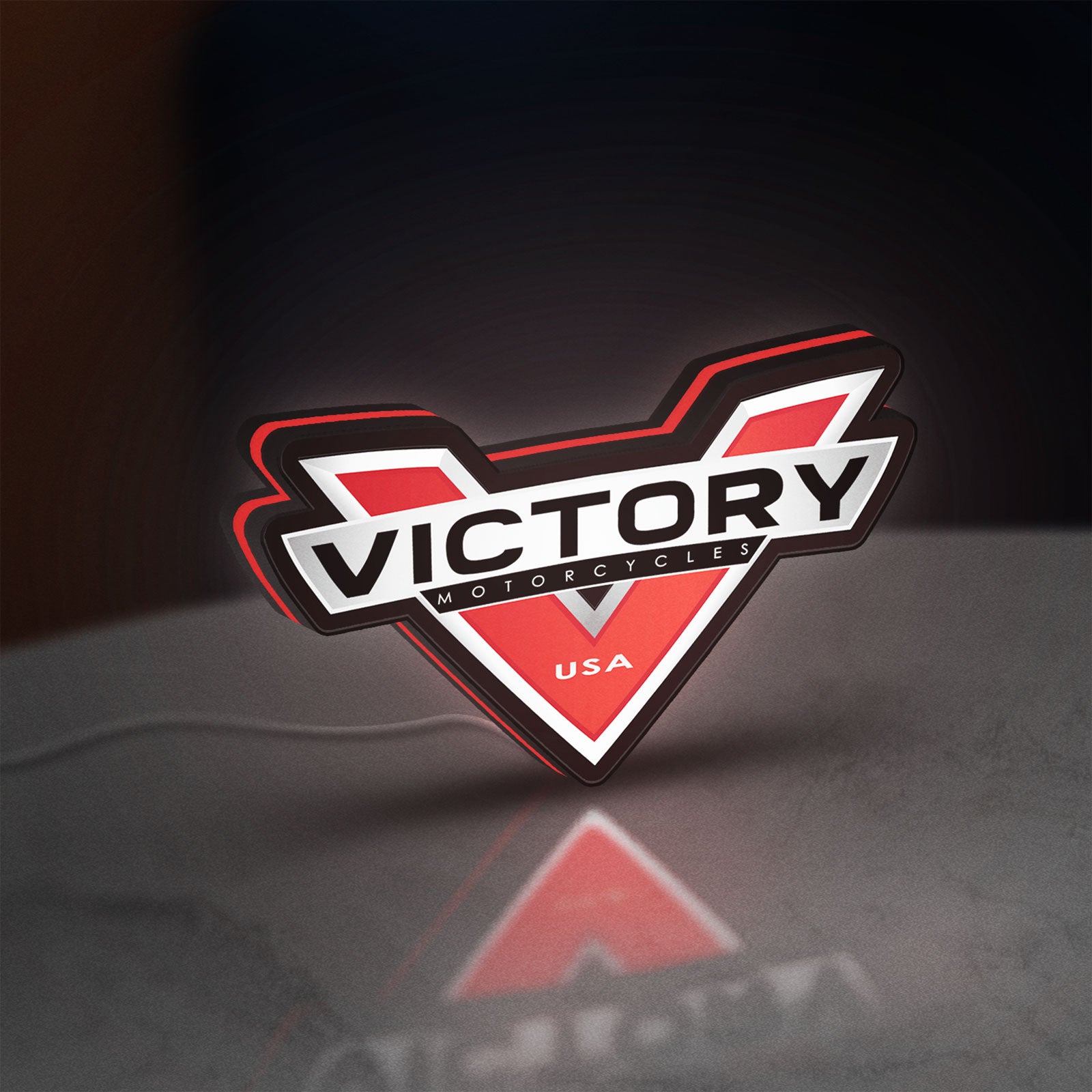 Victory Motorcycles LED lightbox standing on a desk from an angled side view with red glow