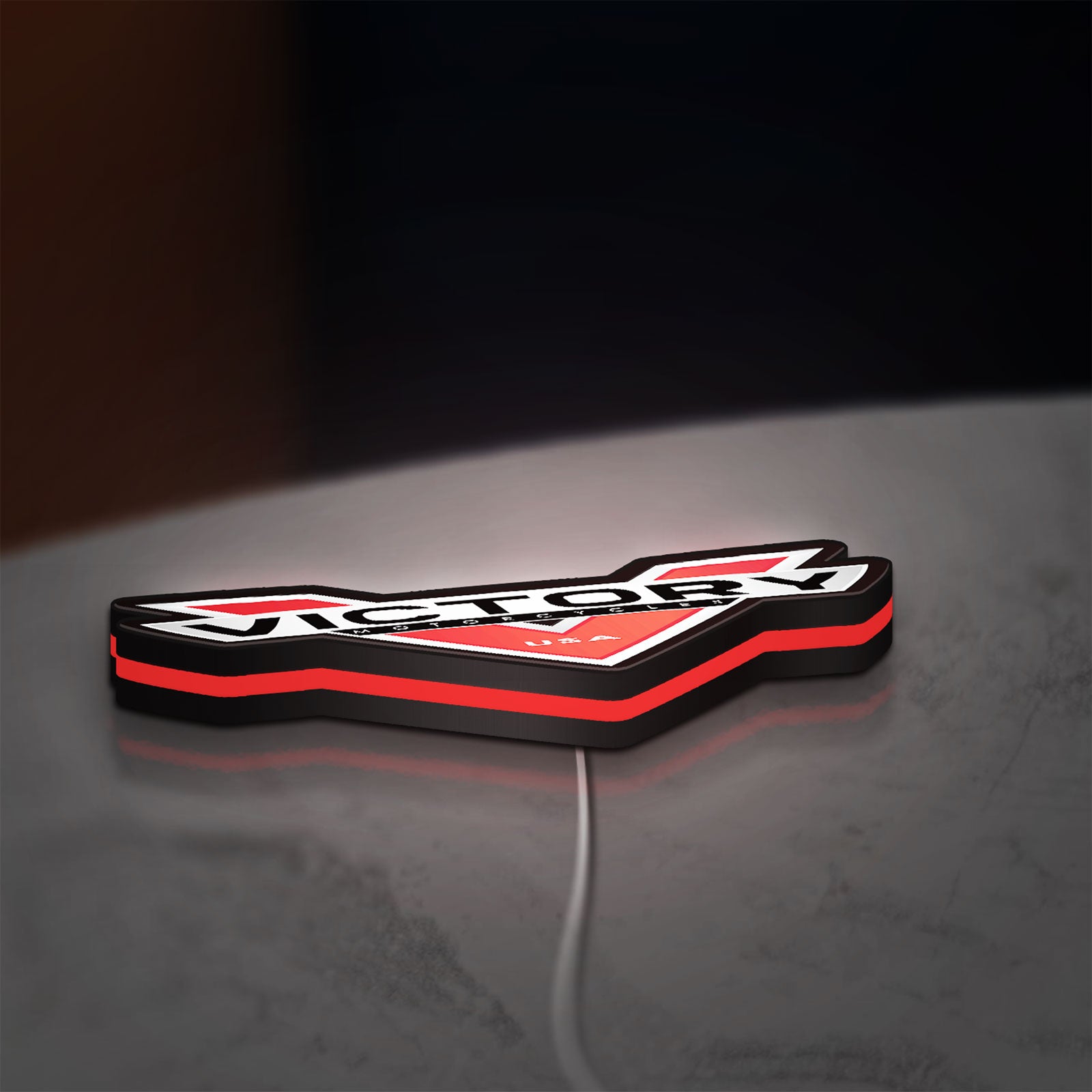 Victory Motorcycles LED lightbox lying flat on a desk with red glow