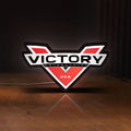 Front view of Victory Motorcycles LED lightbox sign glowing on a wooden desk