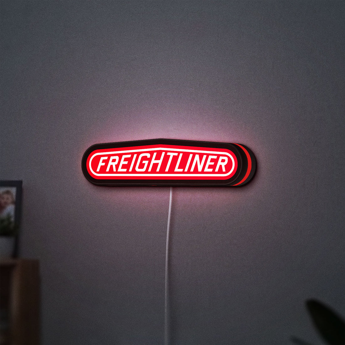 Freightliner Trucks LED lightbox hanging on a wall with red glow
