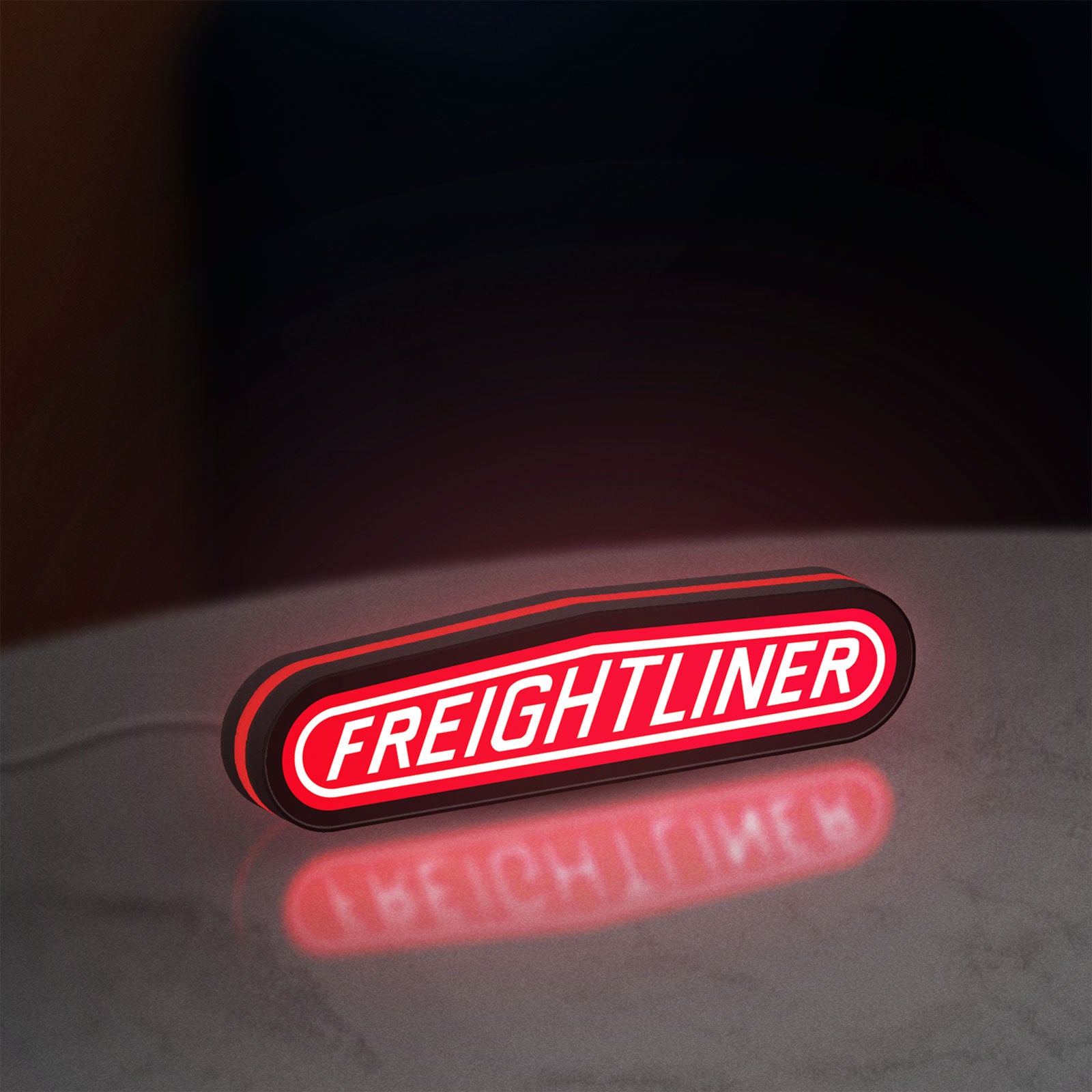 Freightliner Trucks LED lightbox standing on a desk from an angled side view with red glow