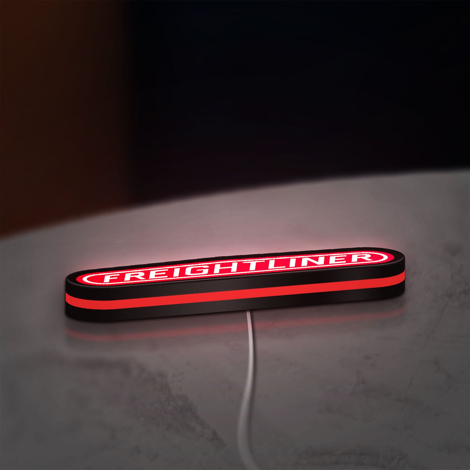 Freightliner Trucks LED lightbox lying flat on a desk with red glow