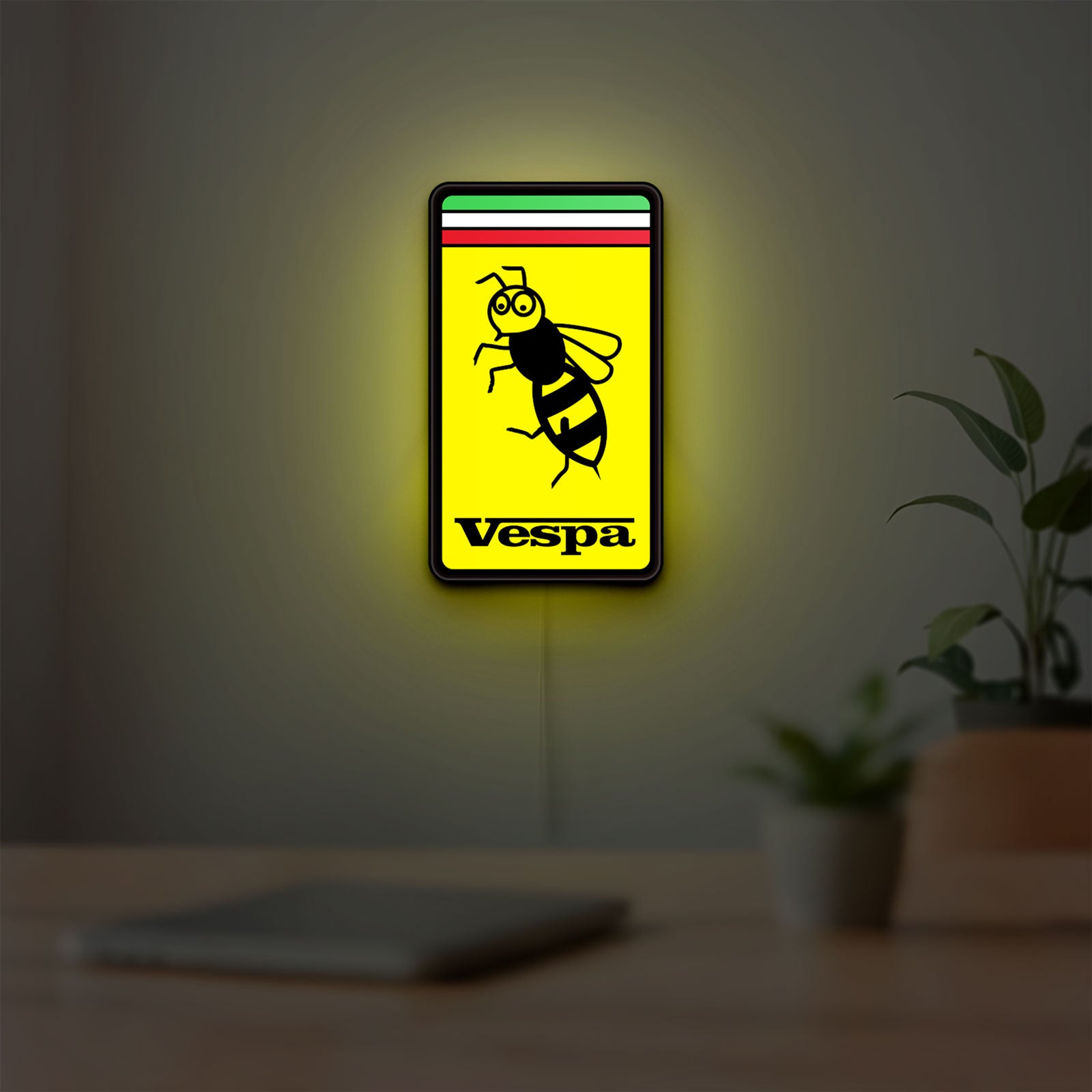 Vespa LED lightbox hanging on a room wall with soft yellow light