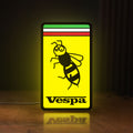 Front view of Vespa LED lightbox sign glowing on a wooden desk