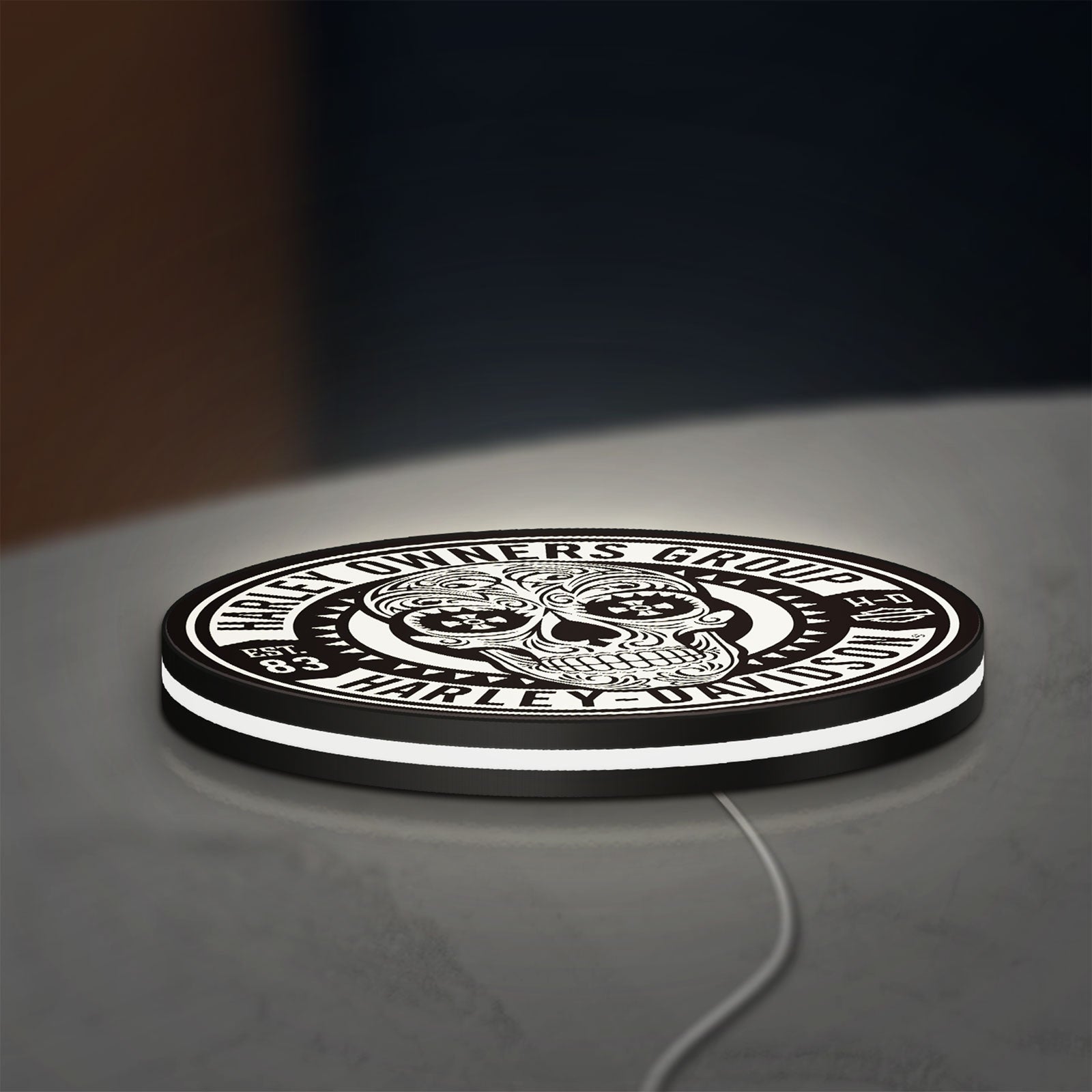 Harley Owners Group LED lightbox lying flat on a desk with white glow