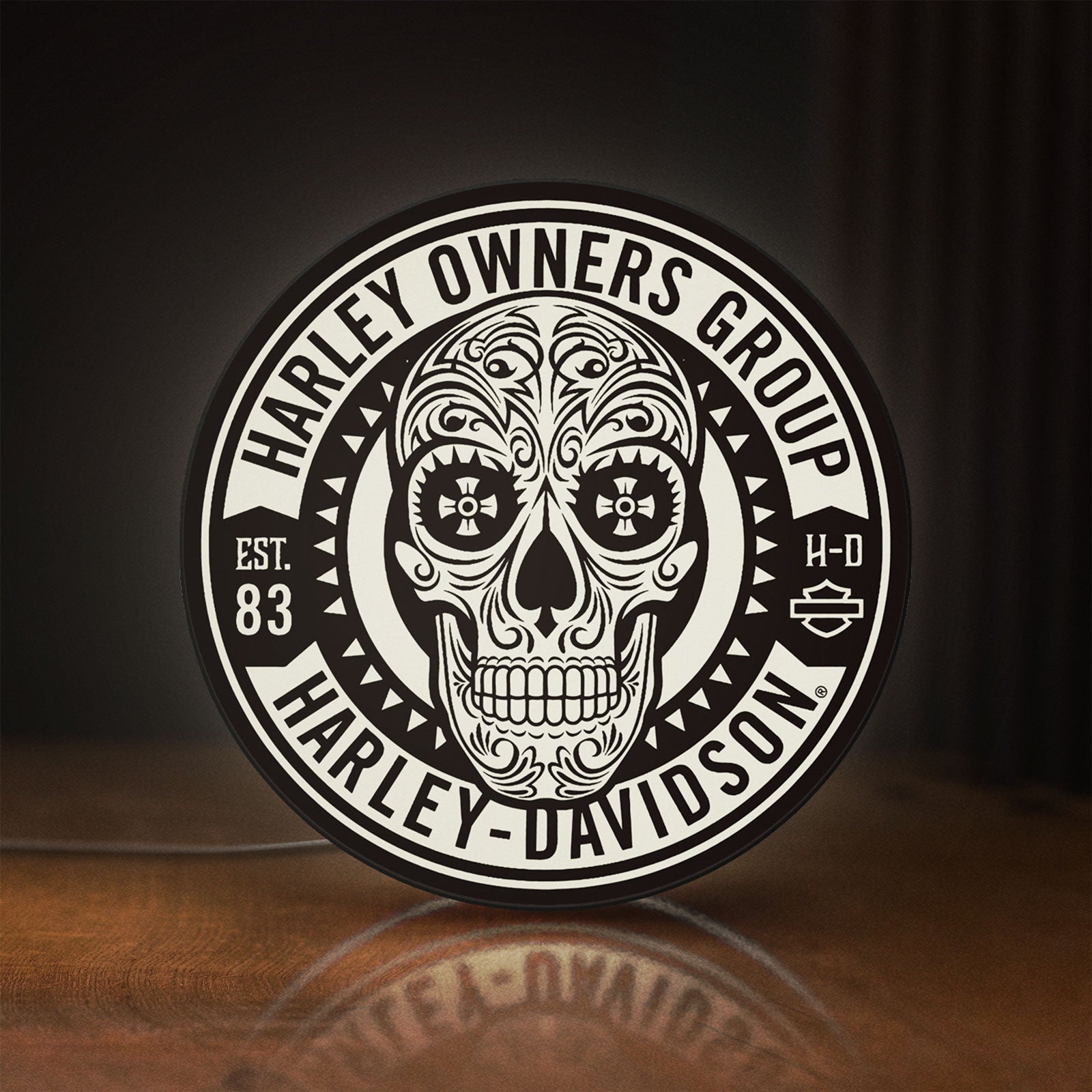 Front view of Harley Owners Group LED lightbox sign glowing on a wooden desk