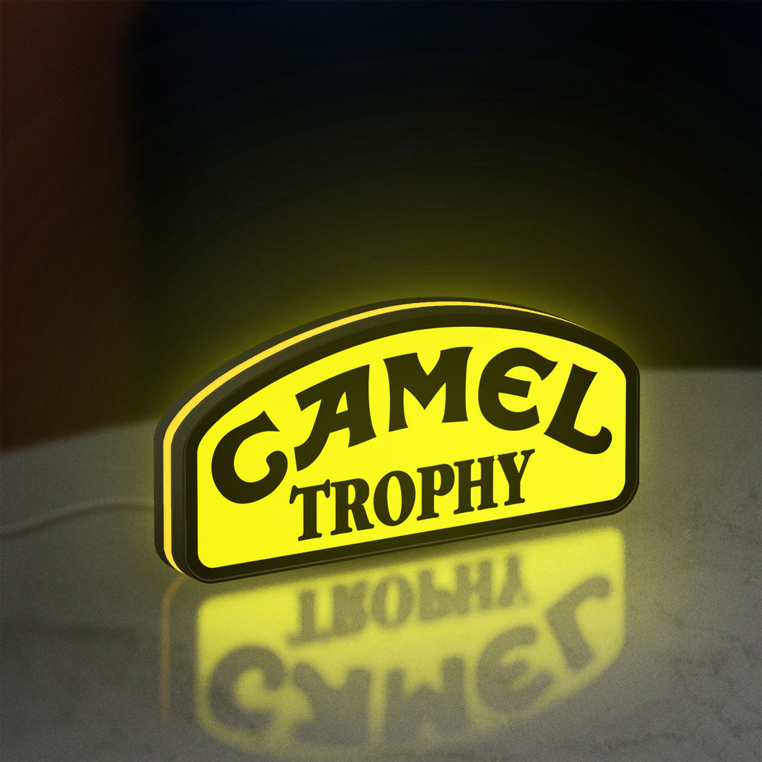 Camel Trophy LED lightbox hanging on a wall with yellow glow