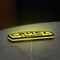 Camel Trophy LED lightbox lying flat on a desk with yellow glow