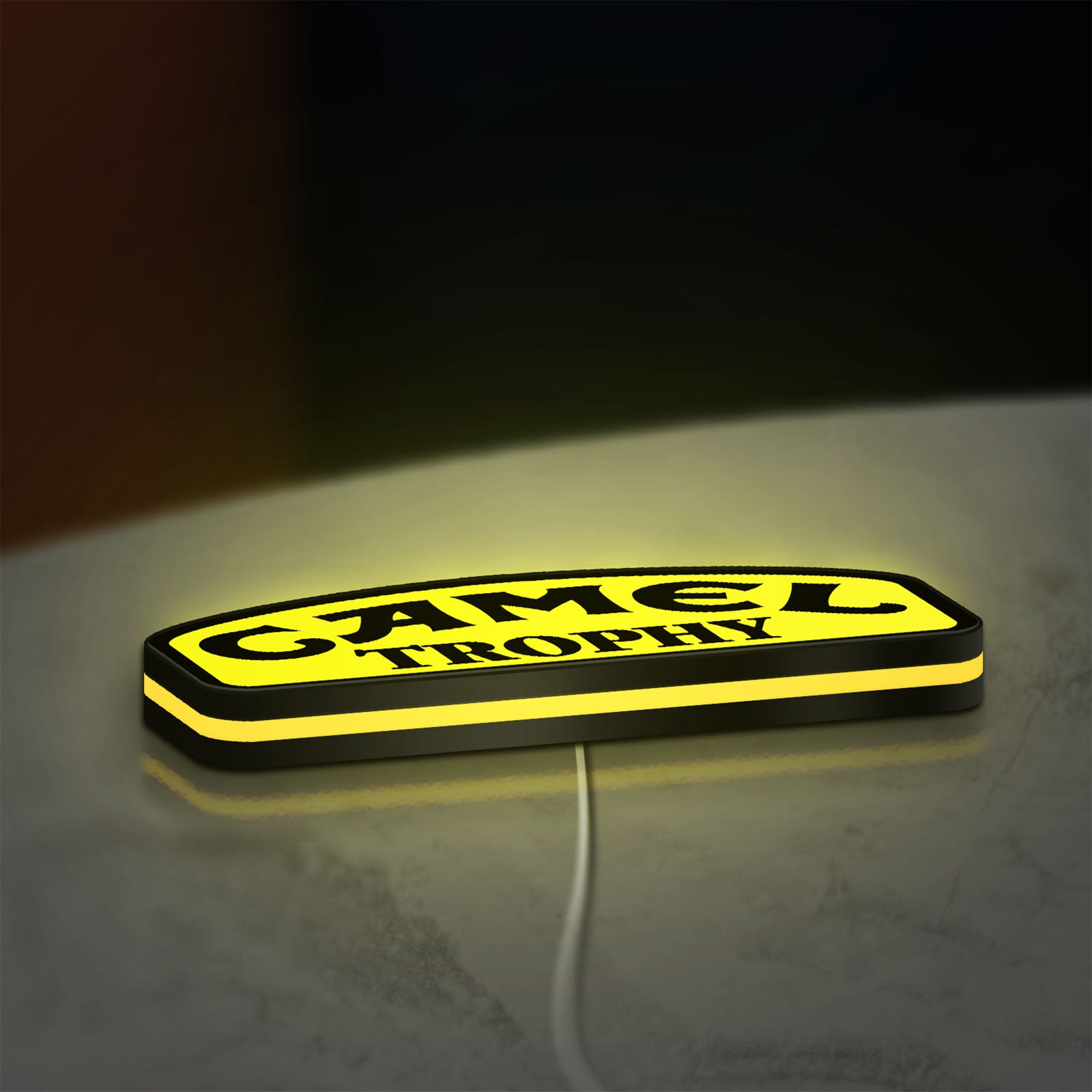 Camel Trophy LED lightbox lying flat on a desk with yellow glow