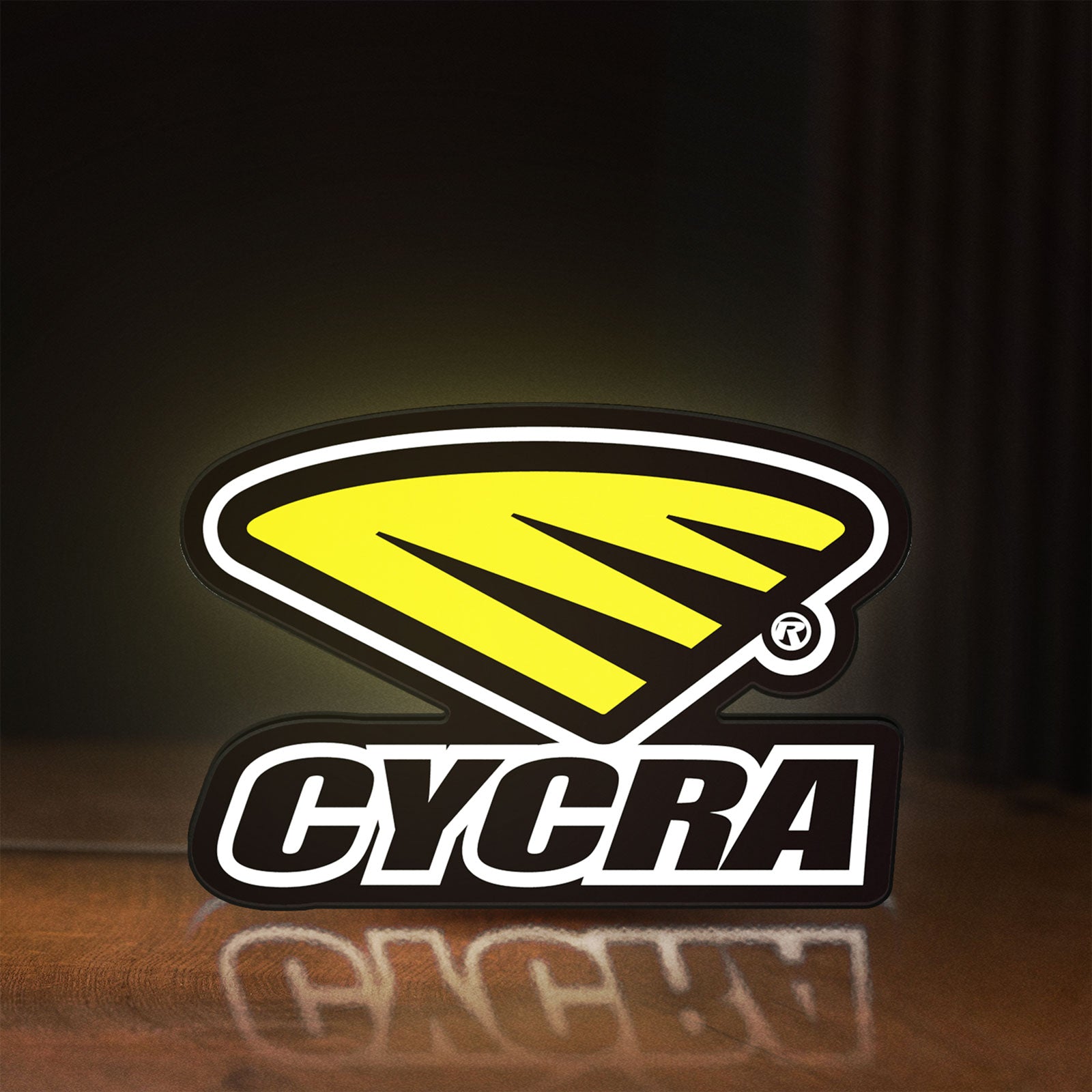 Front view of Cycra Racing LED lightbox sign glowing on a wooden desk