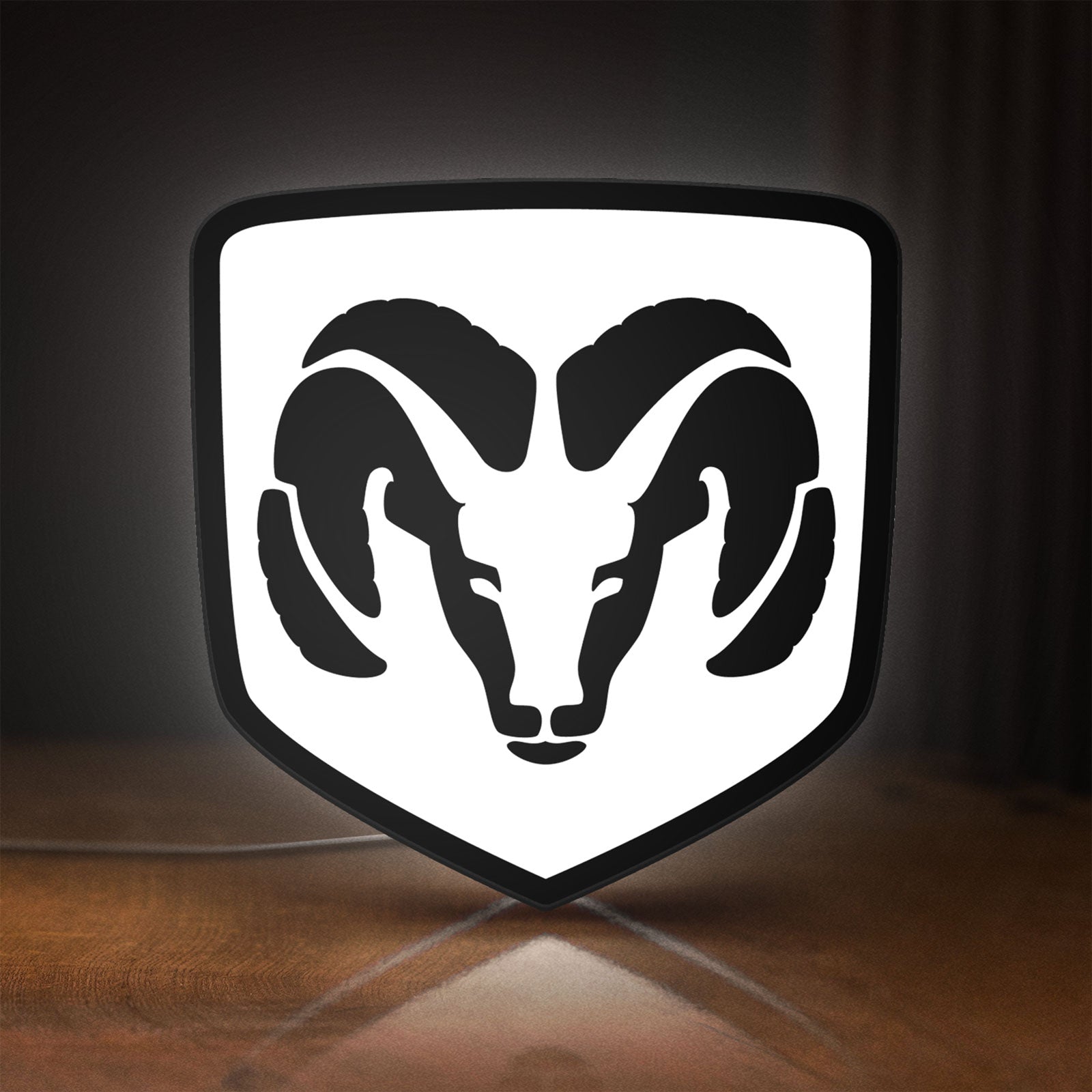 Front view of DODGE RAM LED lightbox sign glowing on a wooden desk