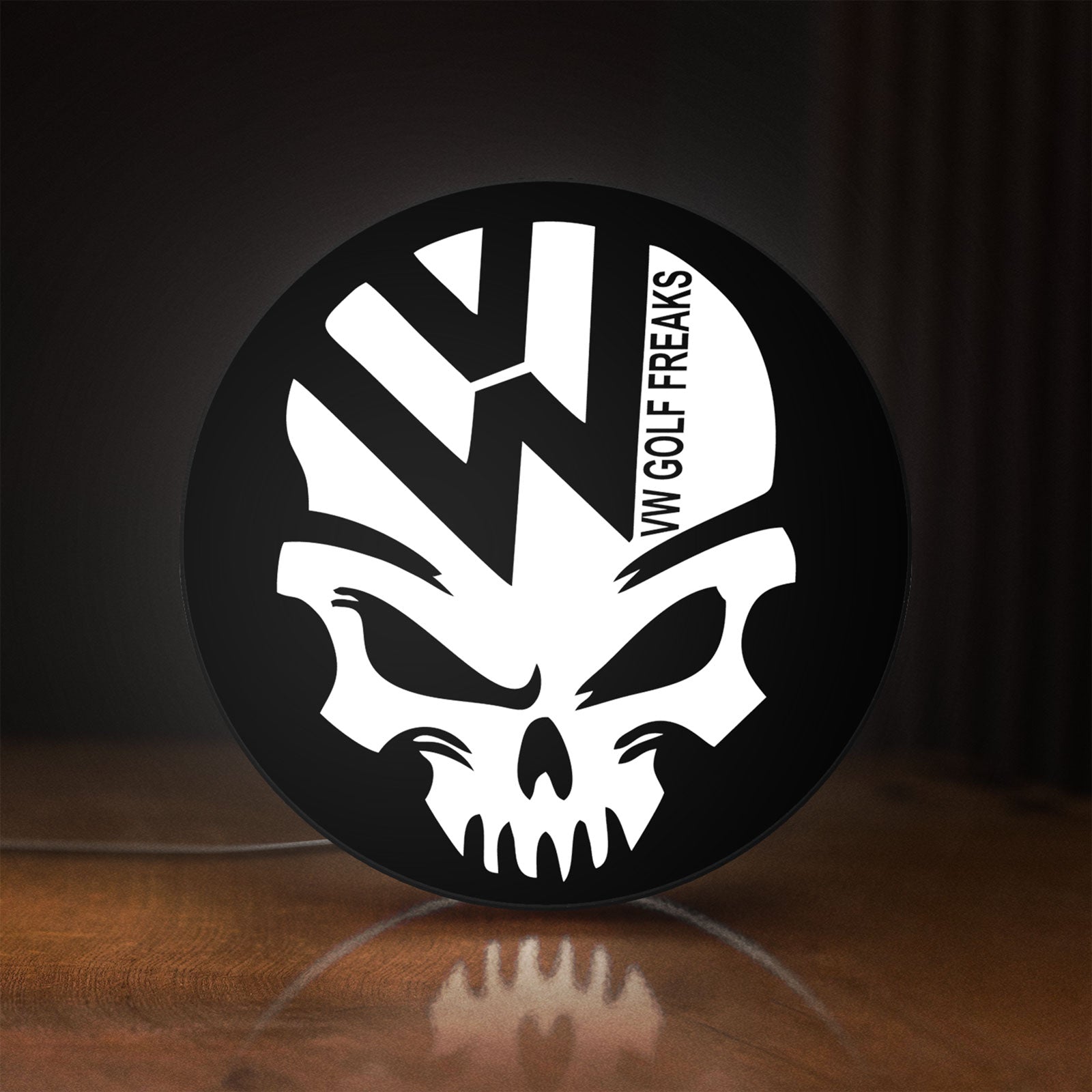 Front view of VW Volkswagen Skull LED lightbox sign glowing on a wooden desk