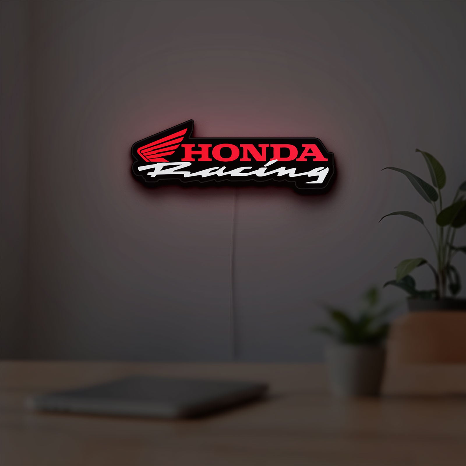 Honda Racing LED lightbox hanging on a room wall with soft red light