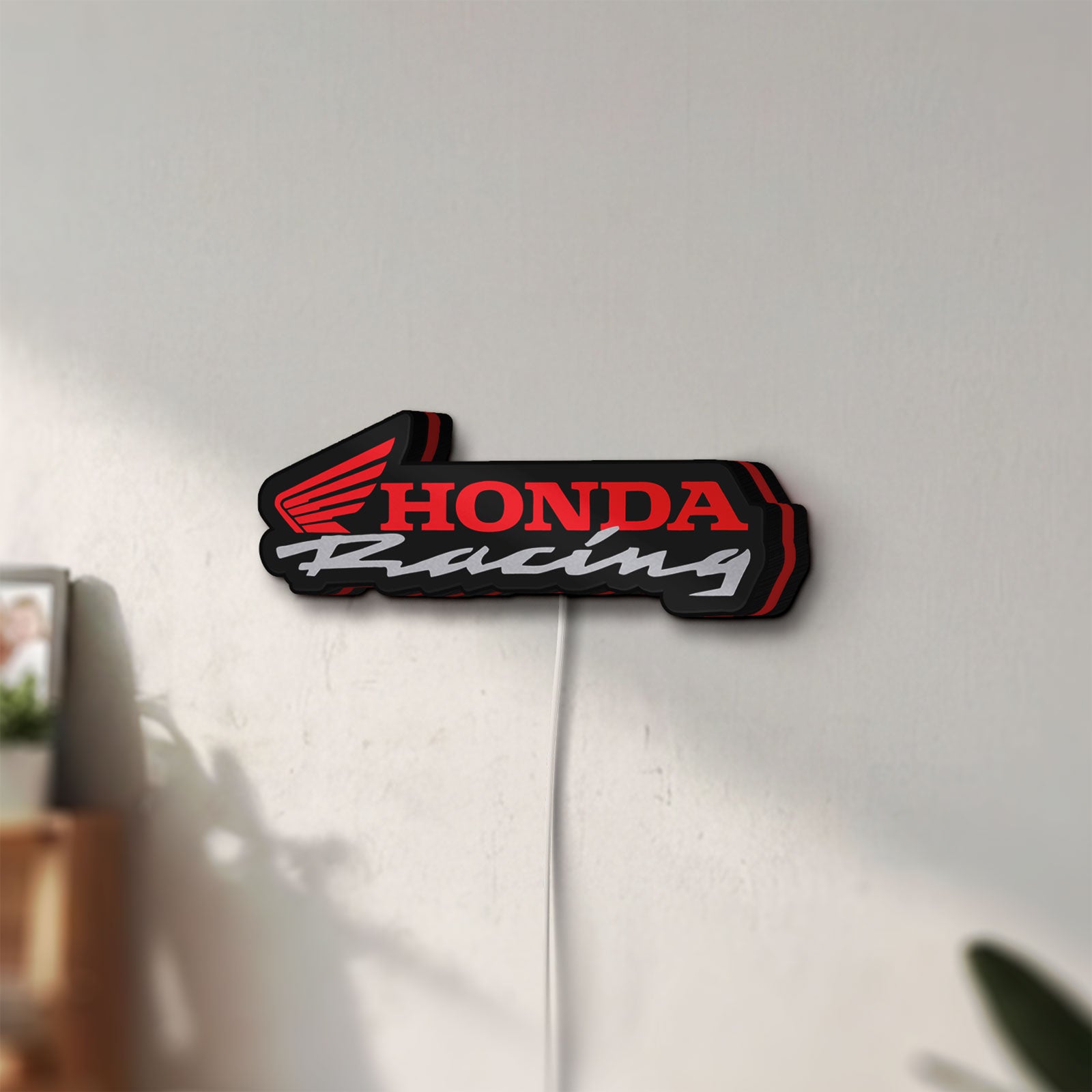 Unlit Honda Racing LED lightbox mounted on a wall in daylight