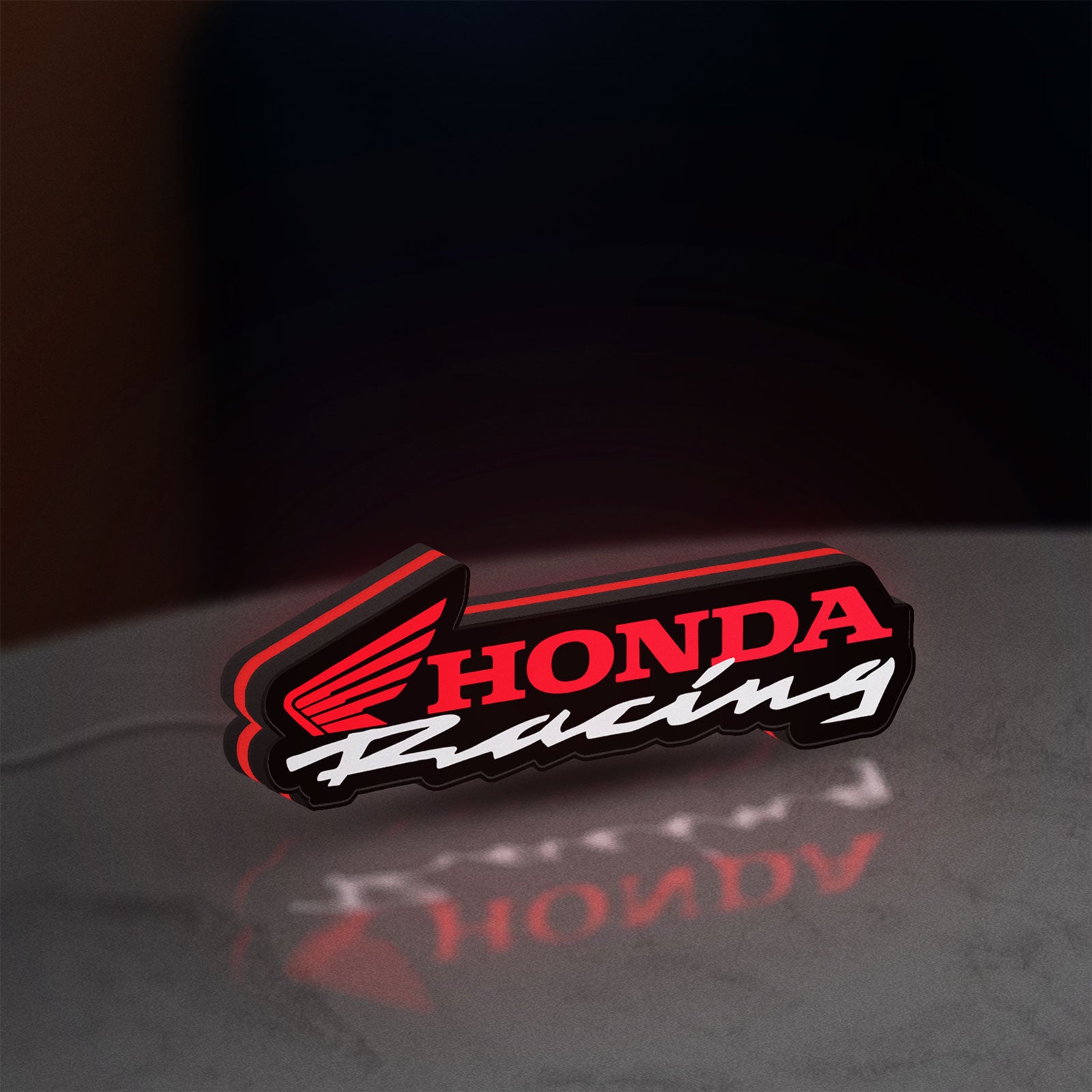 Honda Racing LED lightbox standing on a desk from an angled side view with red glow