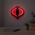 G.I. Joe Cobra LED lightbox hanging on a room wall with soft red light