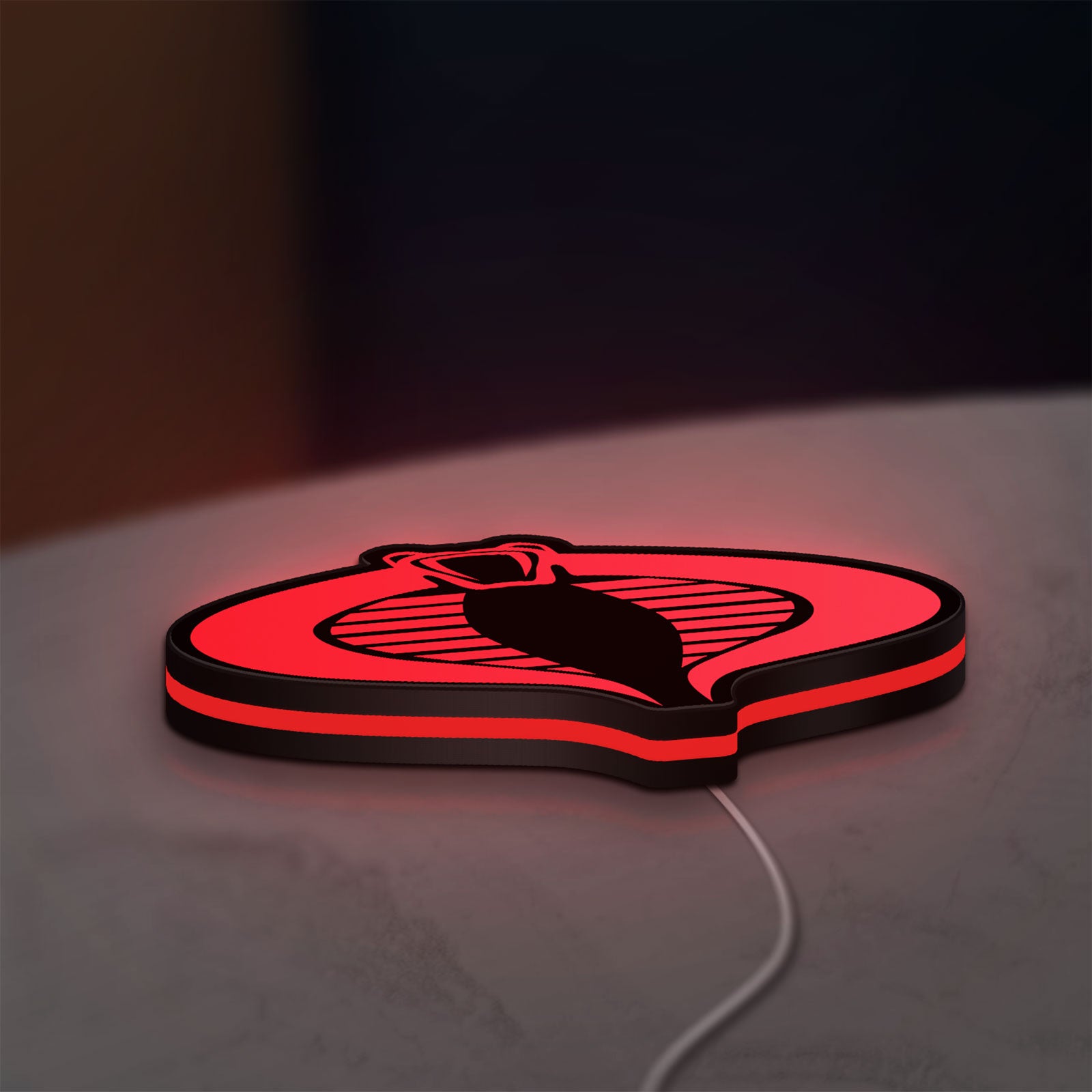 G.I. Joe Cobra LED lightbox lying flat on a desk with red glow