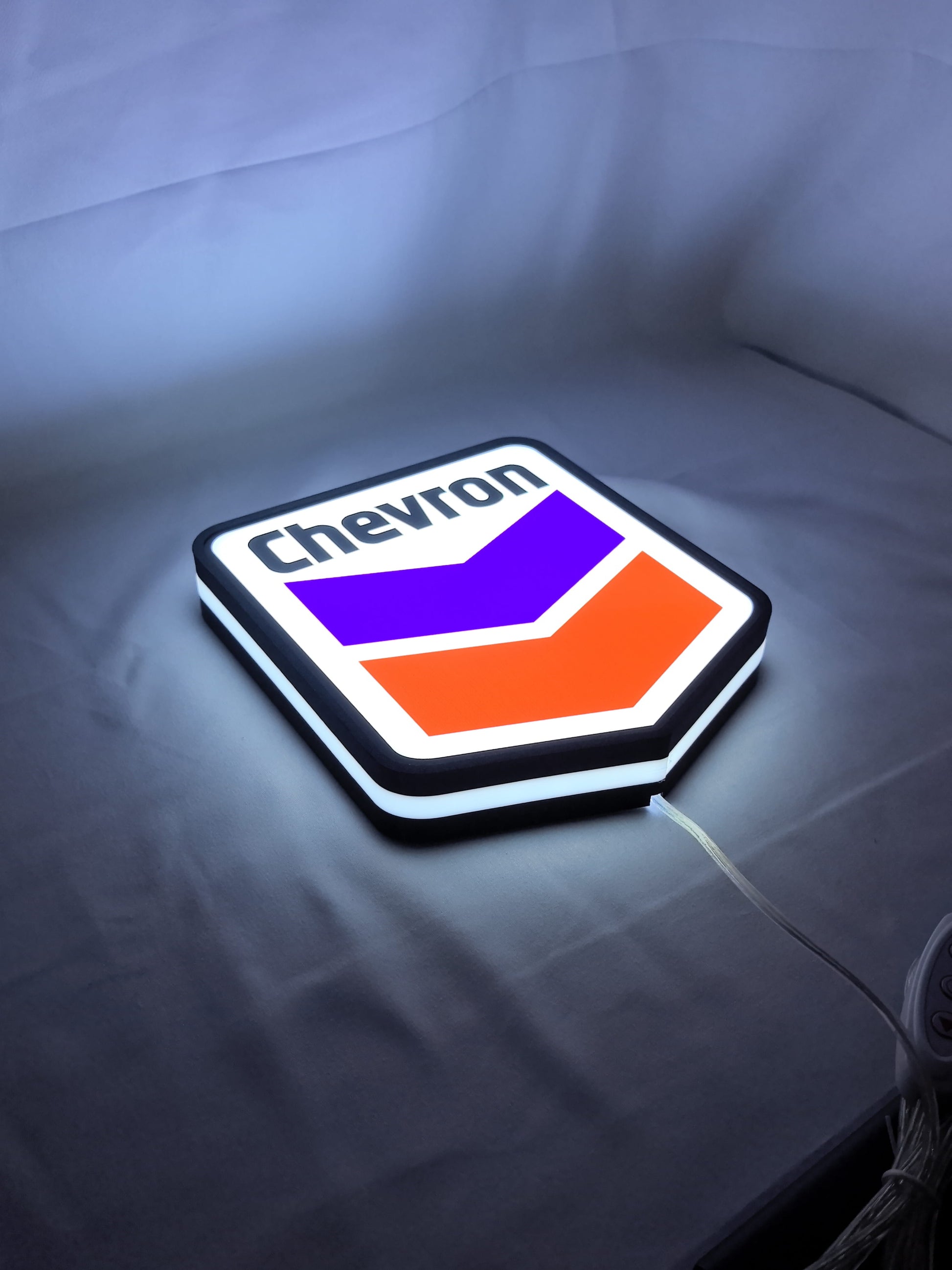 Illuminated flat lay angled view of Chevron Illuminated Sign in 20cm, unique wall art for desk and room decor