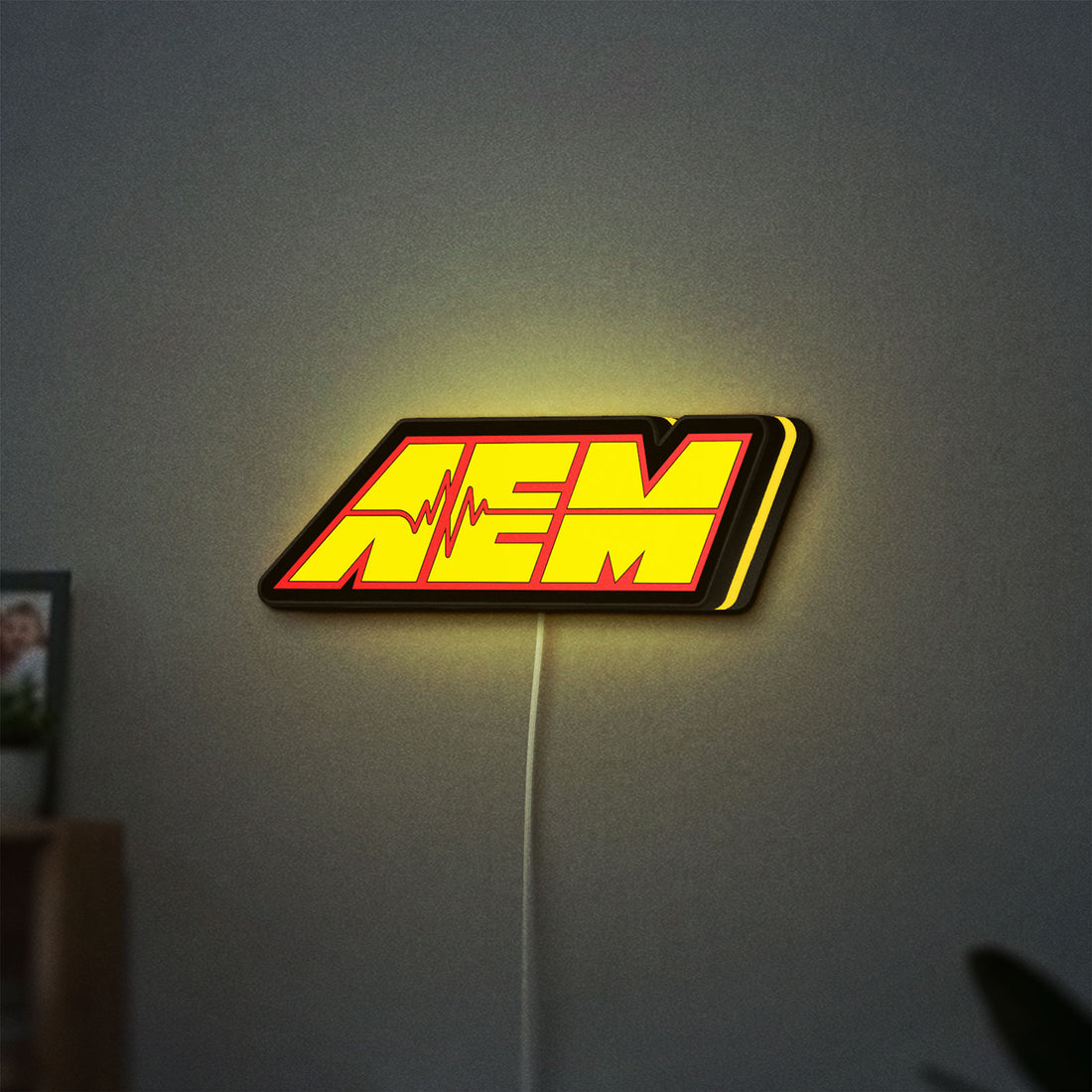 AEM Performance Electronics LED lightbox hanging on a wall with yellow glow