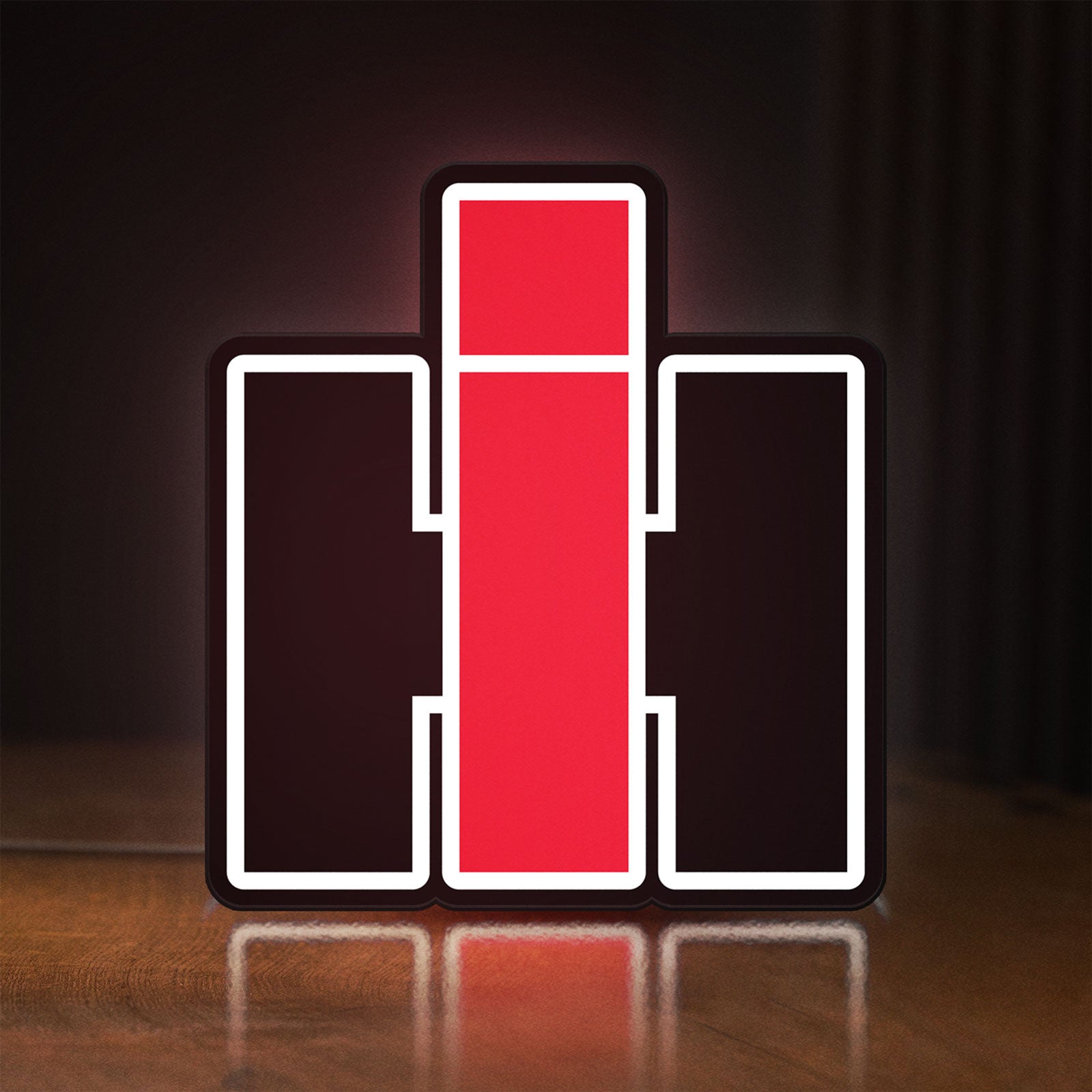 Front view of International Harvester LED lightbox sign glowing on a wooden desk