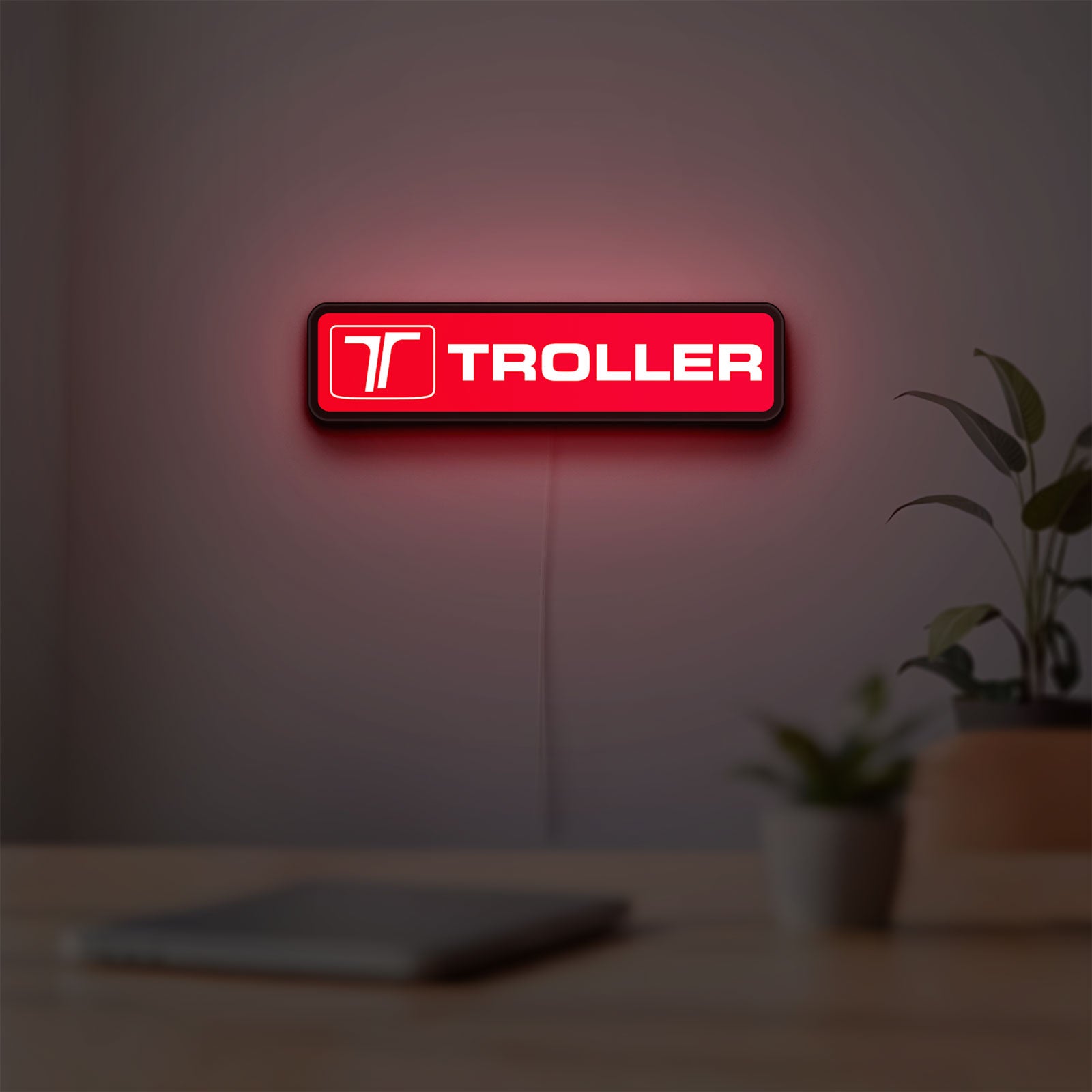 Troller LED lightbox hanging on a room wall with soft red light