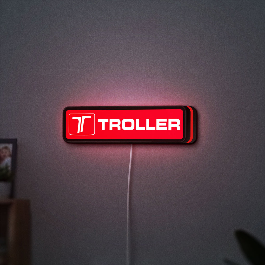Troller LED lightbox hanging on a wall with red glow