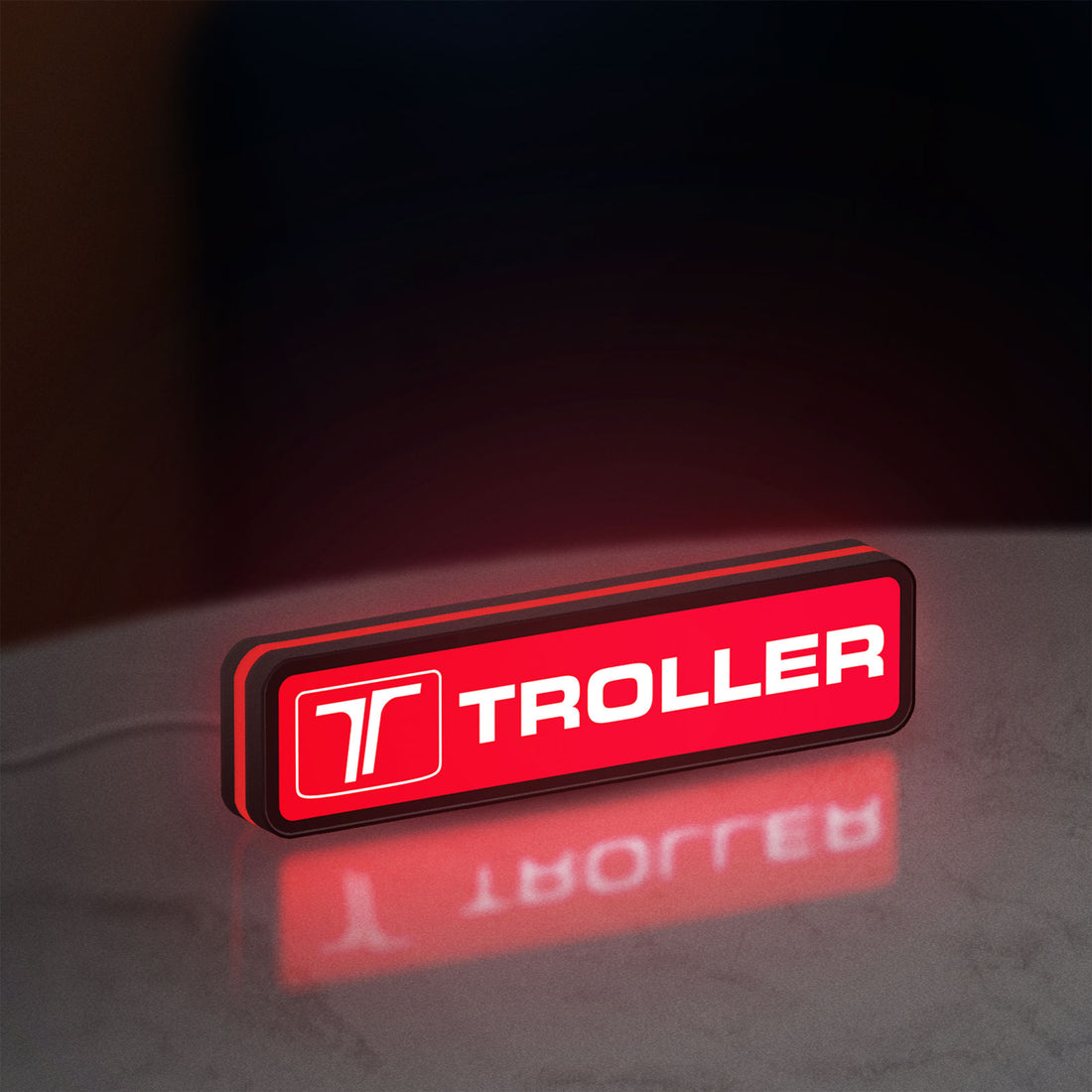 Troller LED lightbox hanging on a wall with red glow
