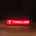 Front view of Troller LED lightbox sign glowing on a wooden desk